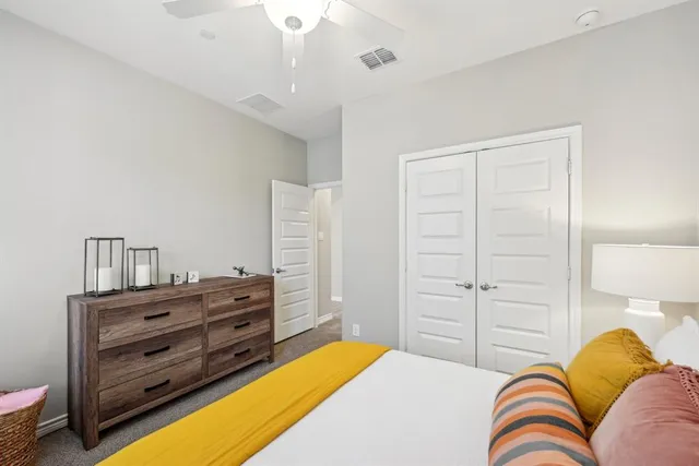 a bedroom with a bed and a ceiling fan