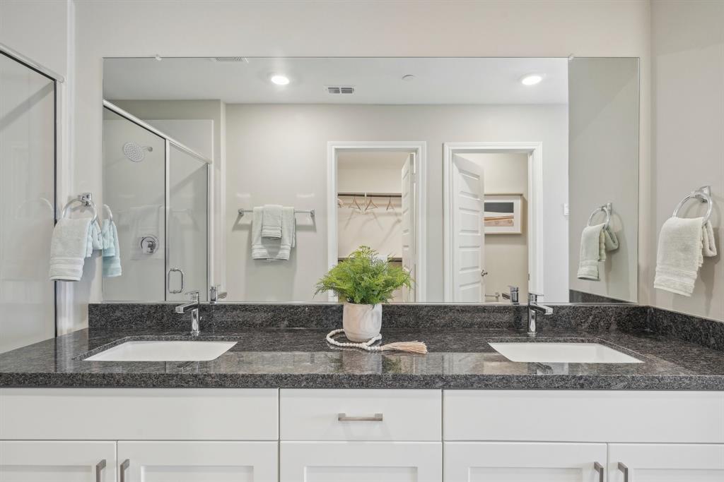 4430 Prairie Crossing, Unit 100 Prosper, TX 75078 - Photo 22 of 38 a bathroom with a granite countertop sink and a mirror