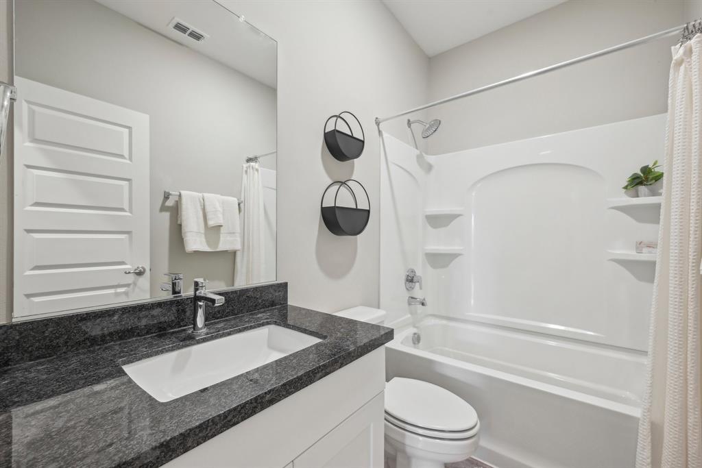 4430 Prairie Crossing, Unit 100 Prosper, TX 75078 - Photo 24 of 34 Full bathroom featuring toilet, vanity, and shower / bathtub combination with curtain