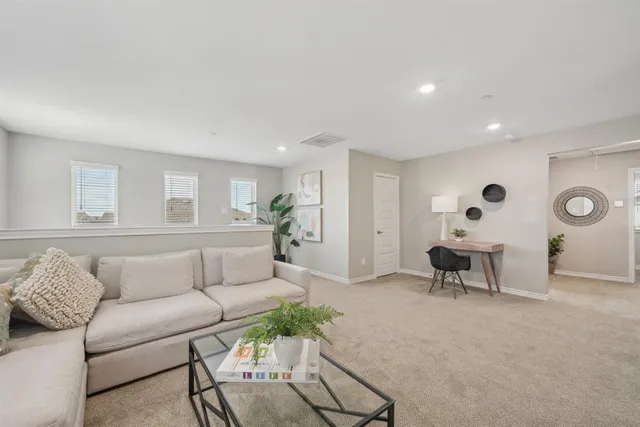 a living room with furniture ceiling fan and a wooden floor