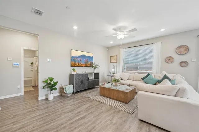 a living room with furniture a window and a flat screen tv