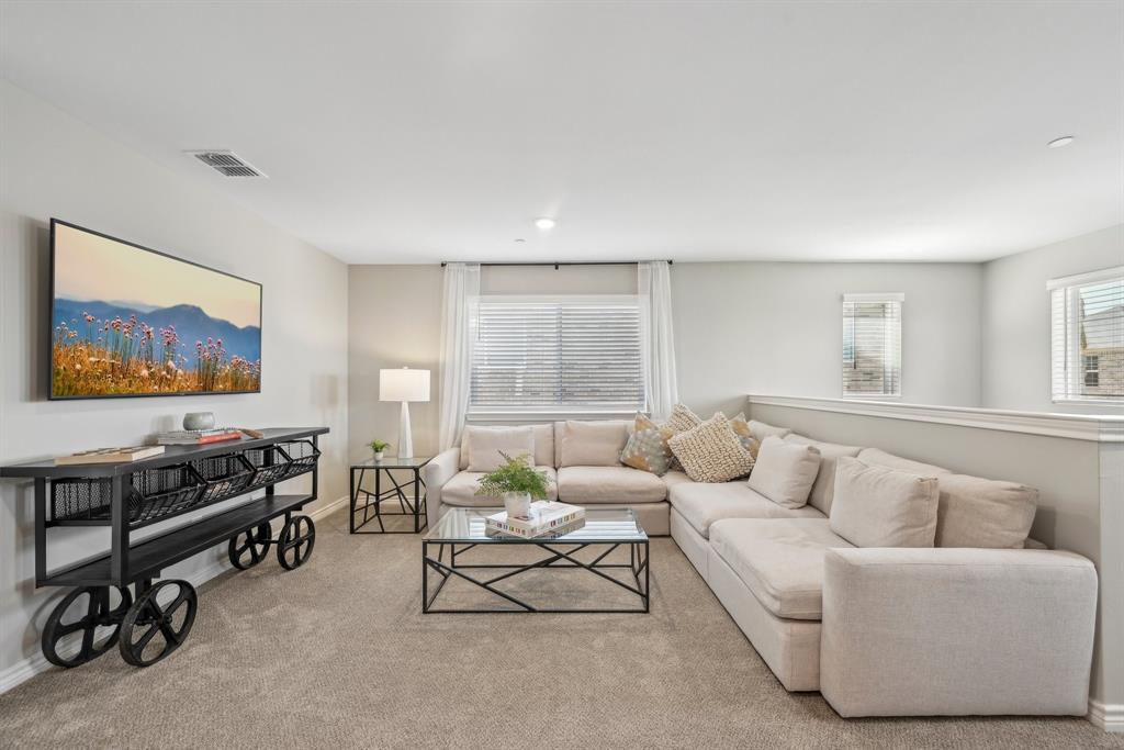 4430 Prairie Crossing, Unit 100 Prosper, TX 75078 - Photo 10 of 38 a living room with furniture a window and a flat screen tv