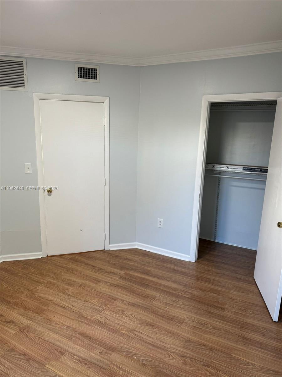 103 Northwest 6th Avenue, Unit 2 Miami, FL 33128 - Photo 16 of 20 a view of an empty room with wooden floor and a window