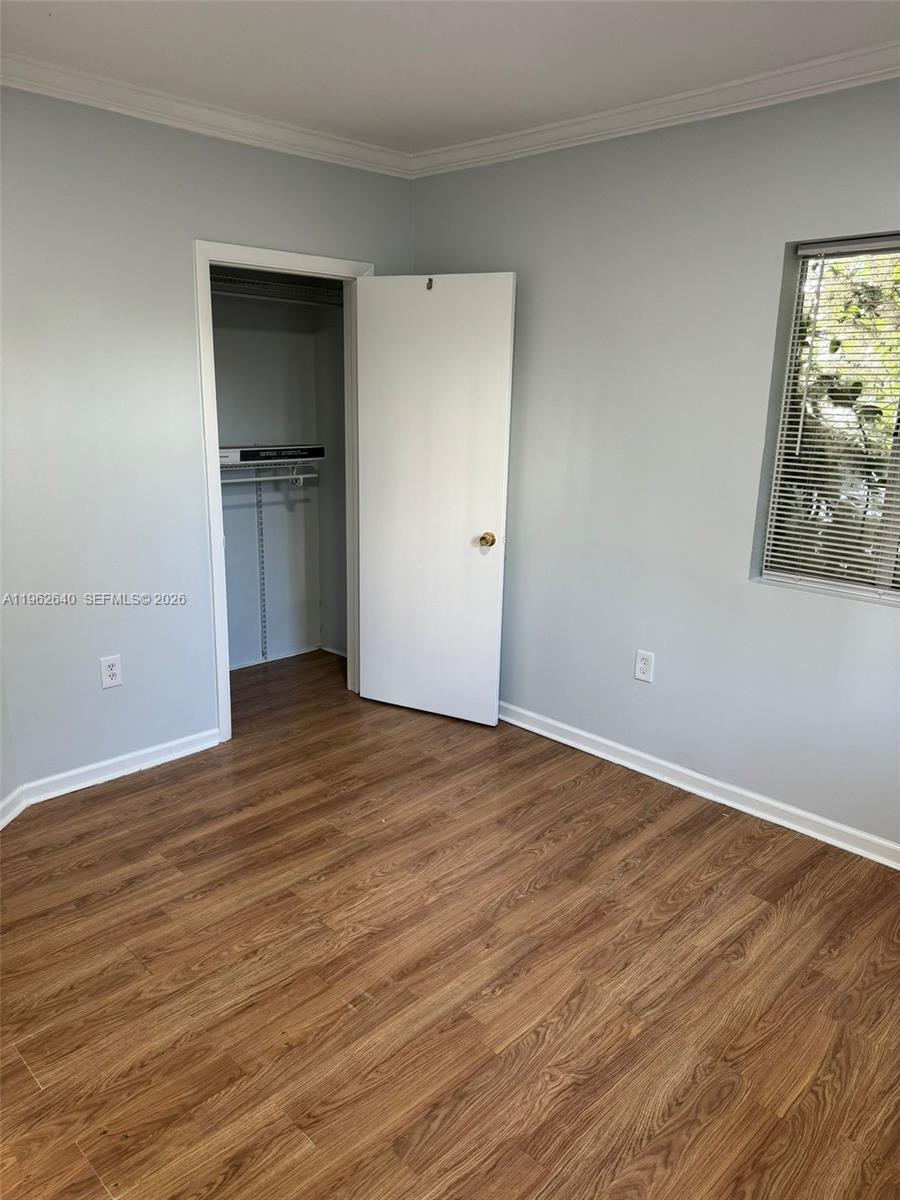103 Northwest 6th Avenue, Unit 2 Miami, FL 33128 - Photo 18 of 20 a view of empty room with wooden floor and kitchen