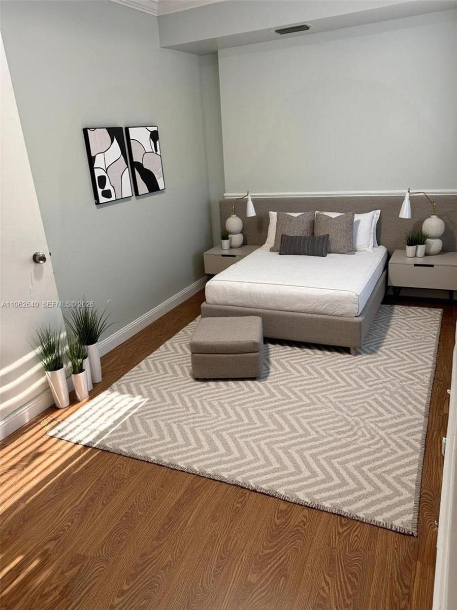 103 Northwest 6th Avenue, Unit 2 Miami, FL 33128 - Photo 2 of 20 a bedroom with a bed and a potted plant on table