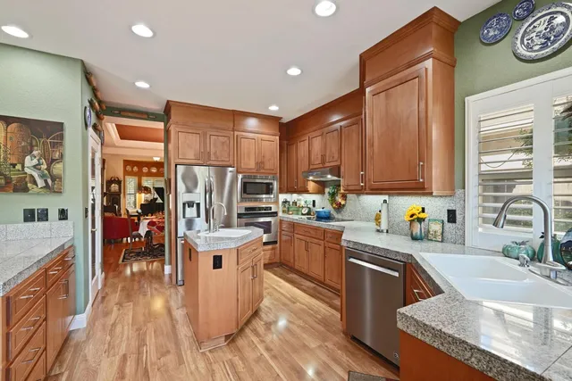 a kitchen with stainless steel appliances granite countertop a sink a stove and cabinets