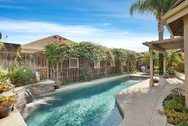 a front view of a house with a yard and potted plants