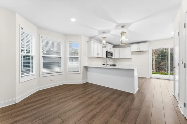 a view of kitchen with cabinets wooden floor and a sink