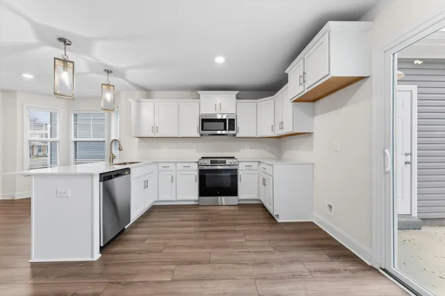 a kitchen with granite countertop white cabinets and white appliances