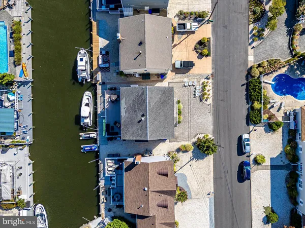 an aerial view of residential houses with outdoor space and parking