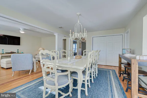 a view of a dining room with furniture a chandelier and wooden floor
