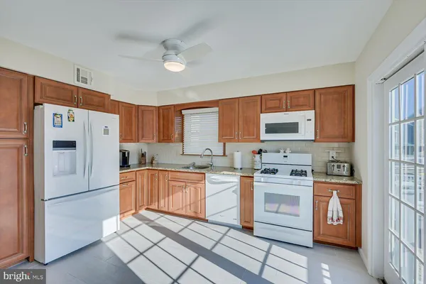 a kitchen with stainless steel appliances granite countertop a refrigerator sink and stove