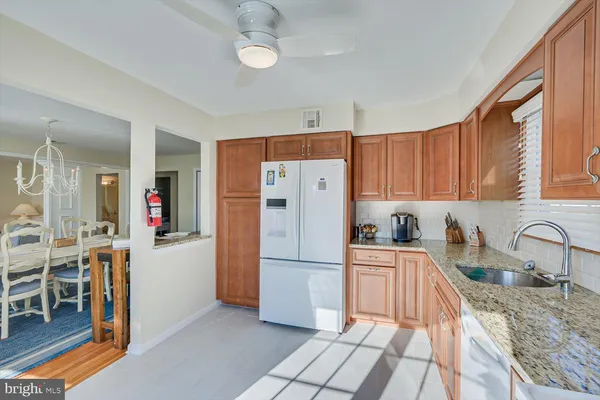 a kitchen with granite countertop a refrigerator and a sink