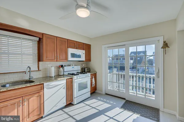 a kitchen that has a sink a stove and cabinets