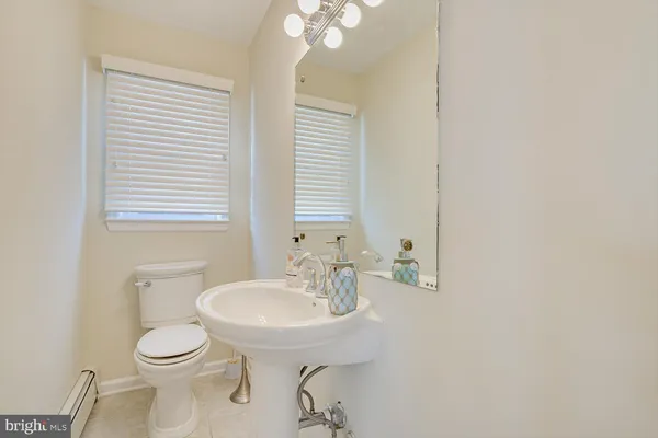 a bathroom with a toilet a sink and mirror