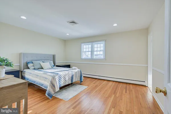 a spacious bedroom with a bed and a dresser