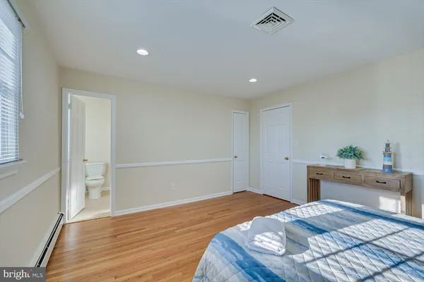 a bedroom with a bed and a potted plant on dresser