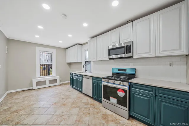 a kitchen with stainless steel appliances granite countertop a stove a sink and a microwave