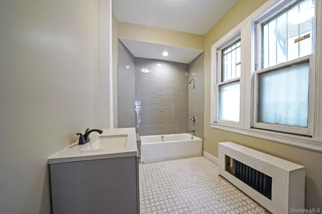 a bathroom with a bathtub a sink and a window