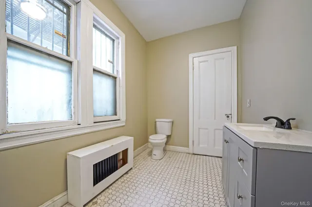 a bathroom with a sink a toilet and a window