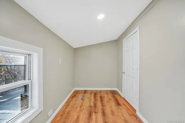 a view of a room with wooden floor and a window
