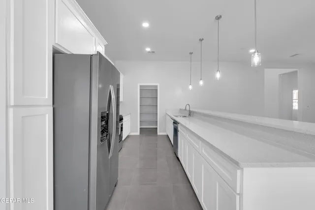 an empty room with white cabinet and windows