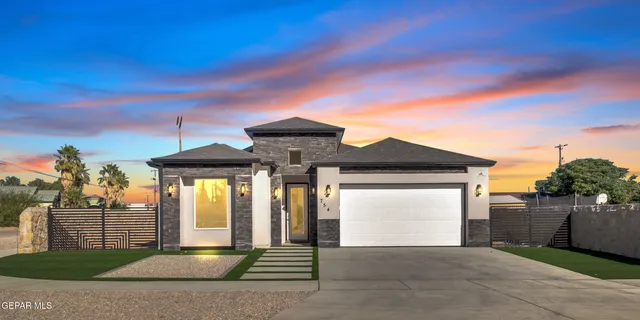 a front view of a house with a garden and garage