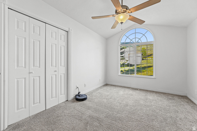 4117 North Wolf Ridge Circle Eden, UT 84310 - Photo 13 of 63 Arched window with grilles providing natural light, accompanied by neutral carpeting and white walls