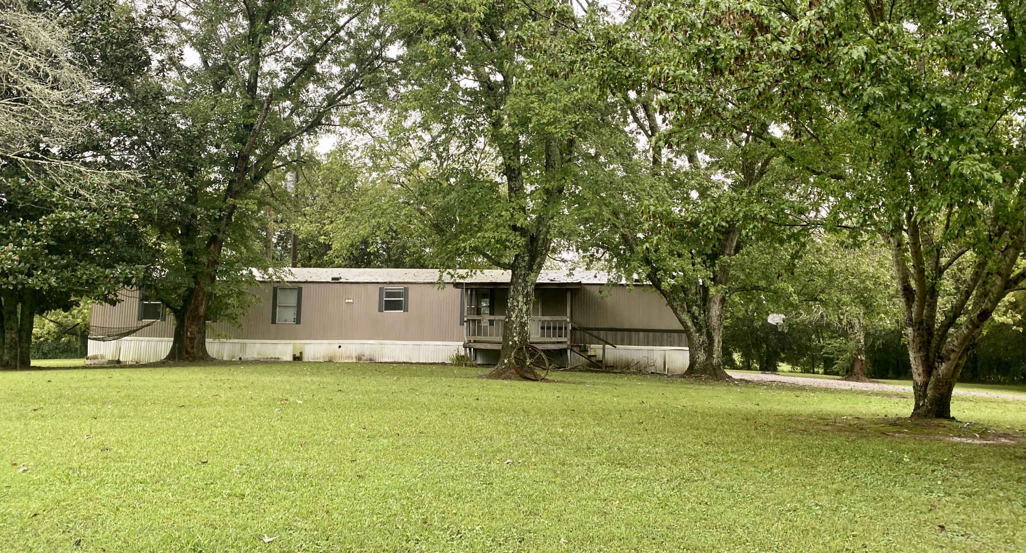 1040 South Commerce Road Watertown, TN 37184 - Photo 1 of 1 a white house that has a tree in front of it