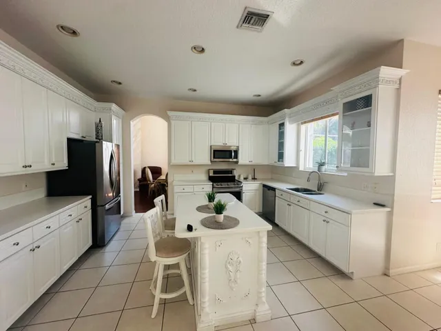 a kitchen with white cabinets and stainless steel appliances