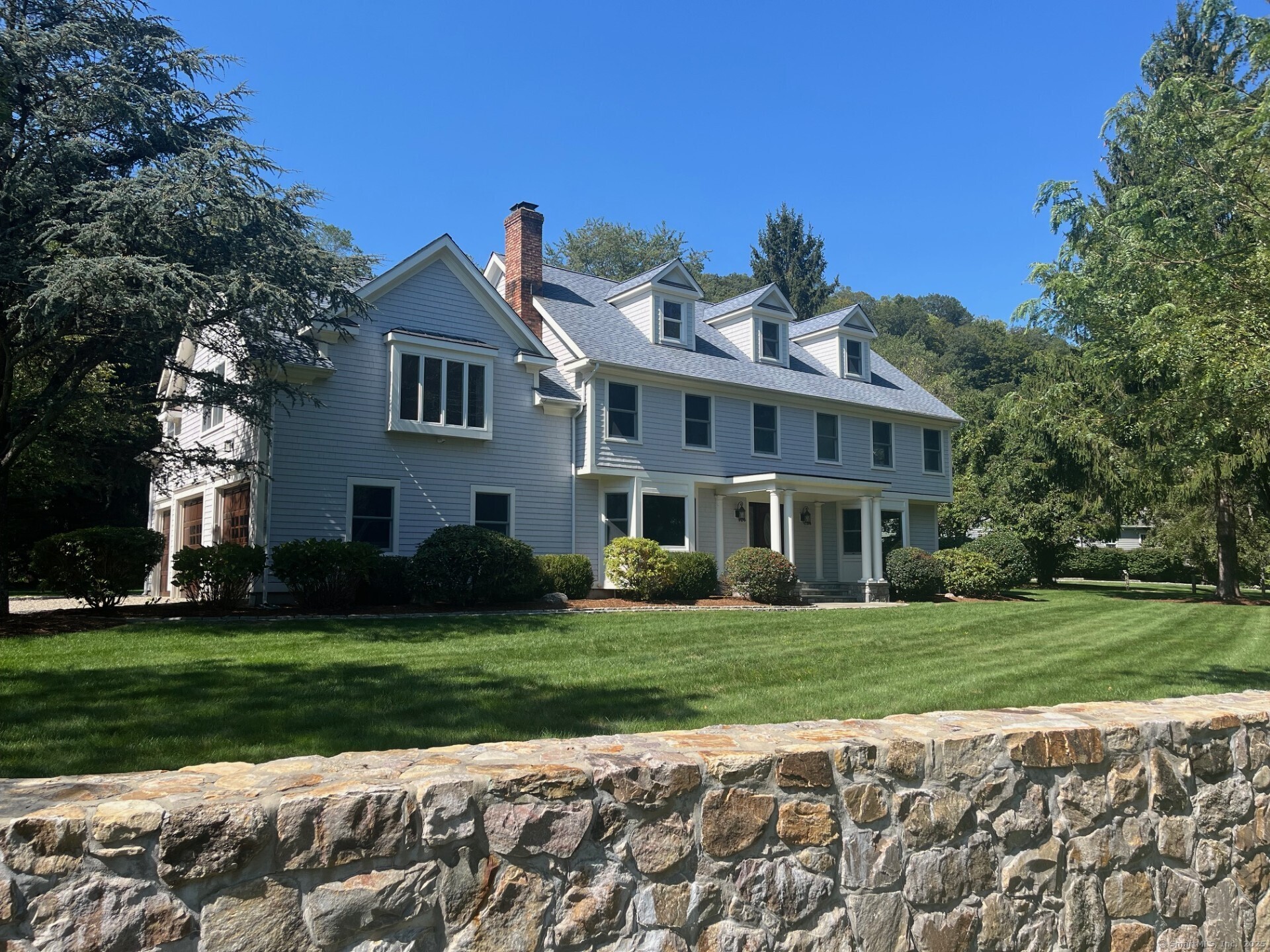 565 Danbury Road Wilton, CT 06897 - Photo 1 of 1 a front view of a house with a garden