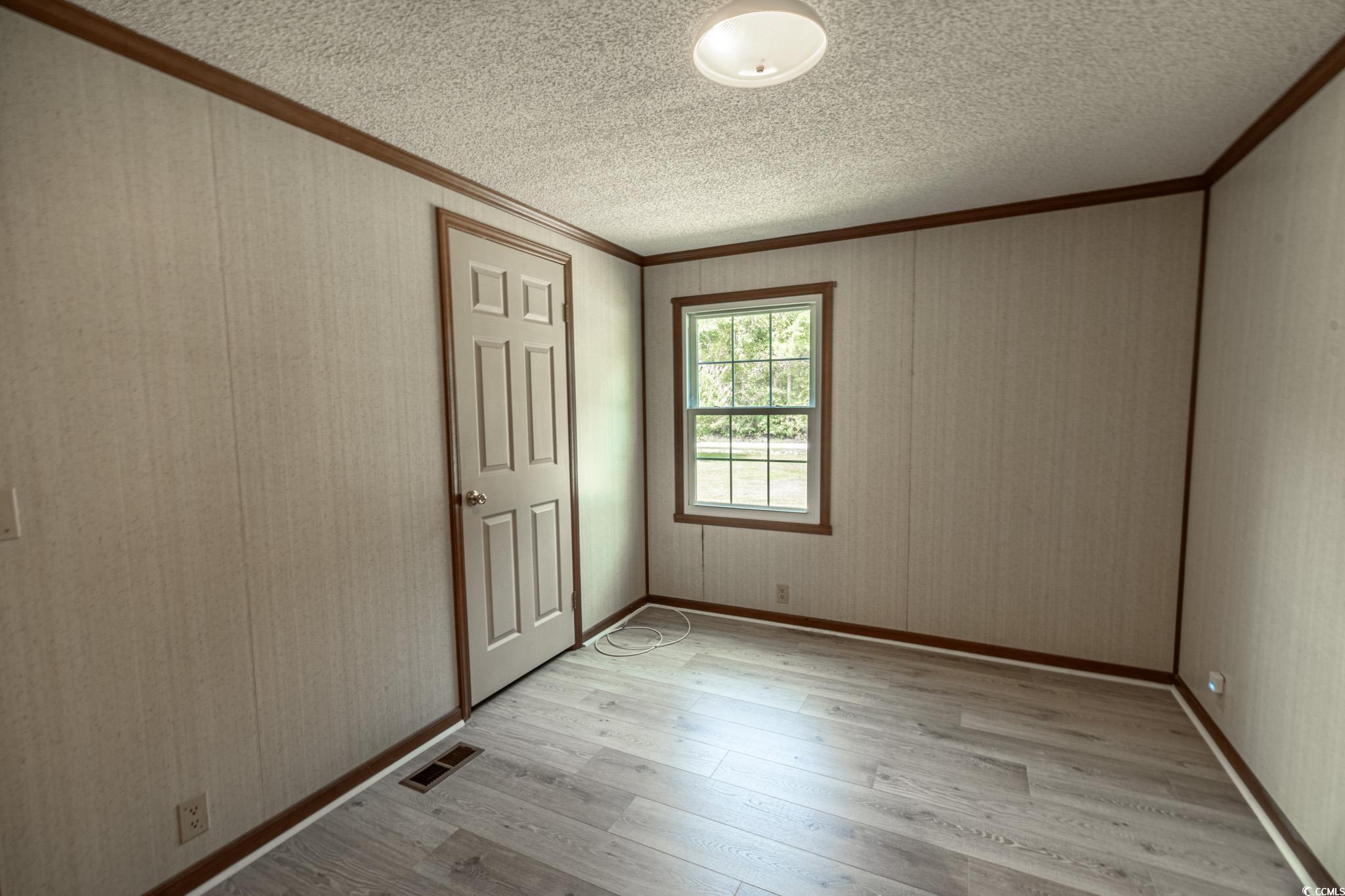 2150 Hazel Road Conway, SC 29526 - Photo 17 of 28 Spare room featuring crown molding, a textured cei
