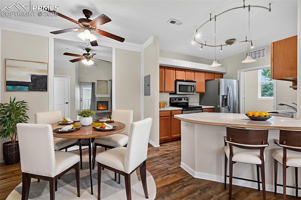 5378 Palomino Ranch Point, Unit 208 Colorado Springs, CO 80922 - Photo 20 of 38 a dining room with stainless steel appliances kitchen island a table and chairs