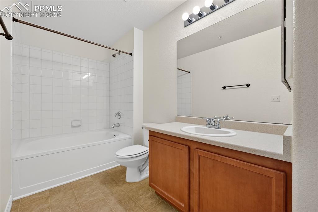5378 Palomino Ranch Point, Unit 208 Colorado Springs, CO 80922 - Photo 32 of 38 a bathroom with a granite countertop sink toilet a mirror and shower