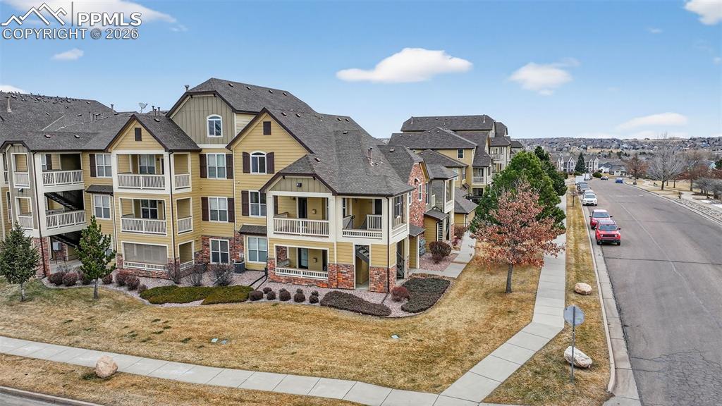 5378 Palomino Ranch Point, Unit 208 Colorado Springs, CO 80922 - Photo 7 of 38 a view of a white house with large windows next to a road