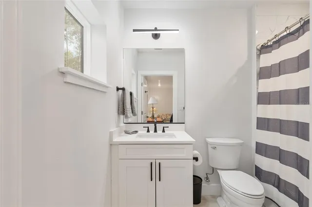 a kitchen with stainless steel appliances granite countertop a refrigerator a sink dishwasher a stove and a dining table with wooden floor