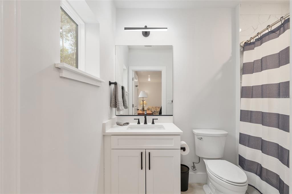2601 Southwest Williston Road, Unit 106 Gainesville, FL 32608 - Photo 14 of 82 a bathroom with a sink a toilet a mirror and shower curtain