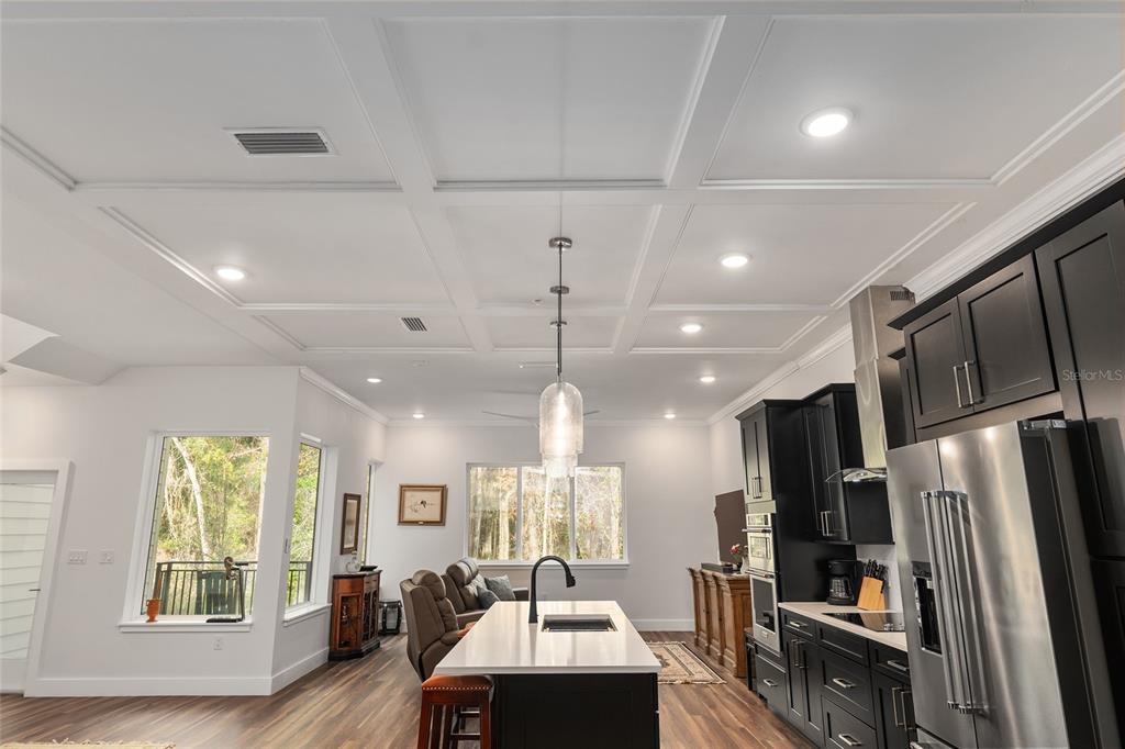 2601 Southwest Williston Road, Unit 106 Gainesville, FL 32608 - Photo 27 of 82 a kitchen with stainless steel appliances granite countertop a refrigerator a sink dishwasher a stove and a dining table with wooden floor