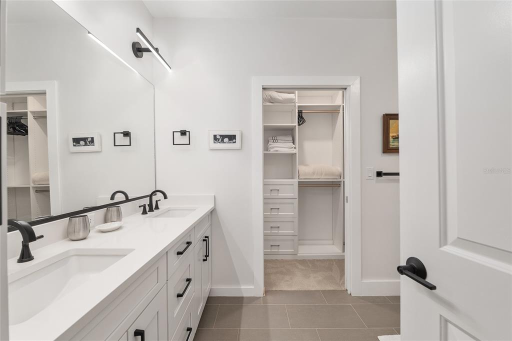 2601 Southwest Williston Road, Unit 106 Gainesville, FL 32608 - Photo 55 of 82 a bathroom with a double vanity sink a mirror and shower