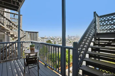 a view of a balcony with wooden chairs