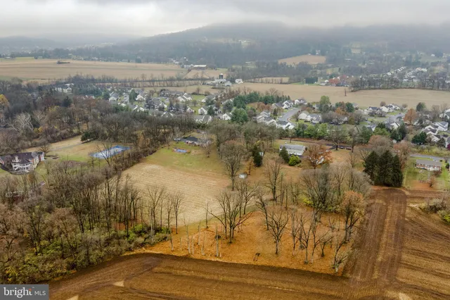 an aerial view of a house with a yard and lake view
