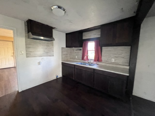 507 Natchez Street Hearne, TX 77859 - Photo 7 of 12 a kitchen with granite countertop wooden cabinets and a flat screen tv