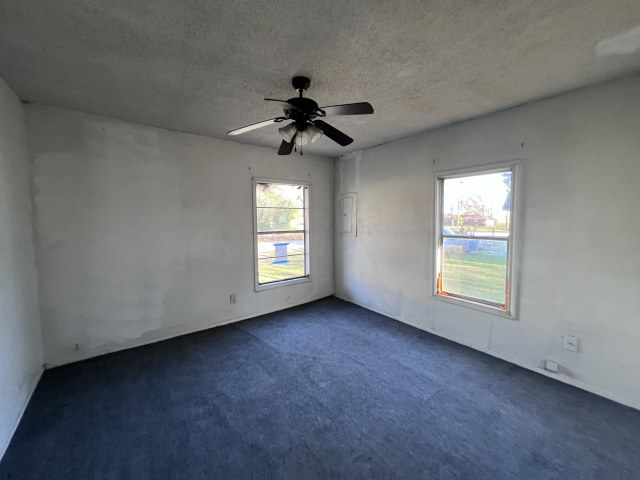 507 Natchez Street Hearne, TX 77859 - Photo 9 of 12 an empty room with windows and fan