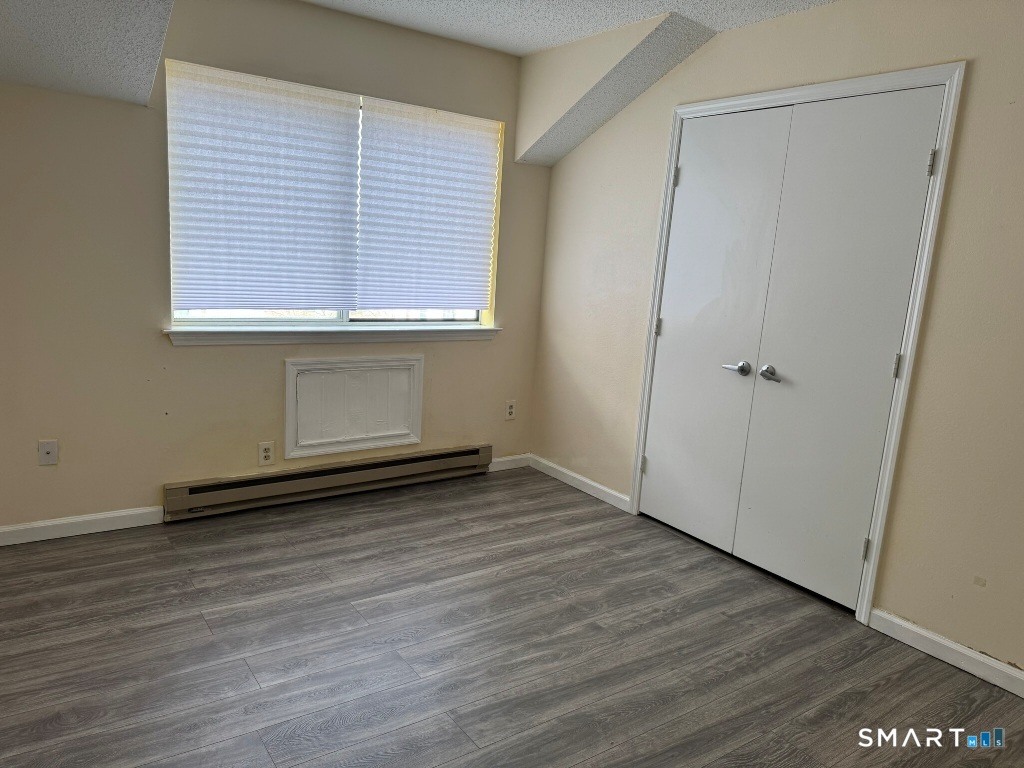 925 Oronoke Road, Unit 30L Waterbury, CT 06708 - Photo 16 of 21 an empty room with wooden floor and window