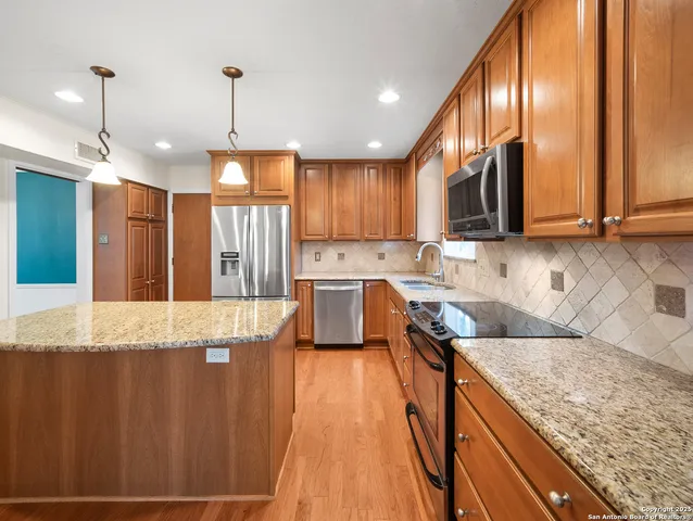a view of a kitchen with kitchen island granite countertop a large window