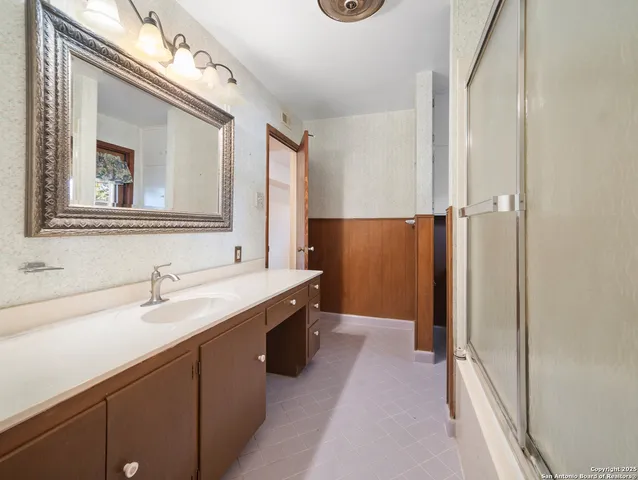 a bathroom with a sink a mirror and a shower