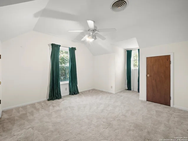 an empty room with closet and a chandelier fan