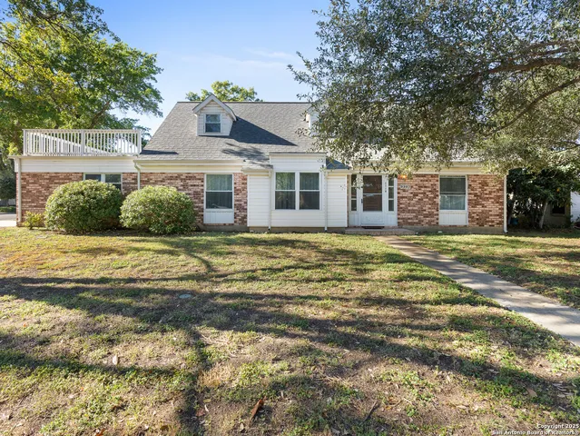 a front view of house with yard and trees around