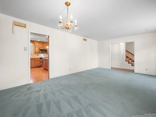 a view of an empty room with a chandelier