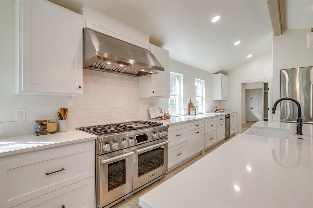 1432 Mount Gilead Road Keller, TX 76262 - Photo 11 of 40 a kitchen with stainless steel appliances a stove a sink dishwasher and cabinets with wooden floor